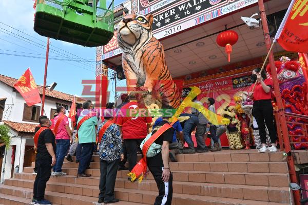 10多名嘉宾及工作人员把300公斤的金虎扛上舞台，以让金虎坐镇鸡场街舞台3天。