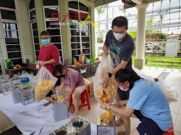 肯纳儿协会的家长及义工带领特殊孩子，制作及包装金瓜片。