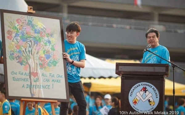史进福（右）于2013年在义走活动标下的主题画，于2019年义走活动回赠给肯纳儿协会。