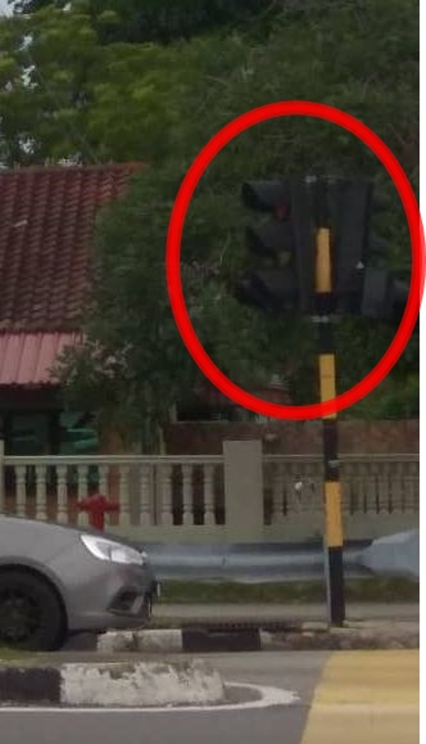 居民提供的图片显示，原本面向镜头的红绿灯，已被撞至移到向右边方向（红圈）。