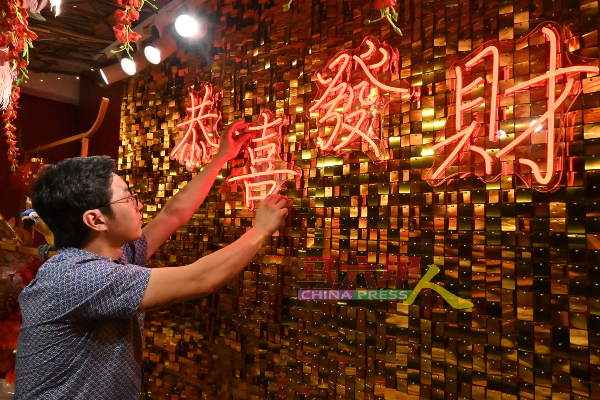 ■黄尊泰特地从中国订购“恭喜发财”的霓虹灯、背景亮片。