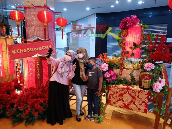 马来同胞对有关春节布景也感兴趣，与家人一同拍照。
