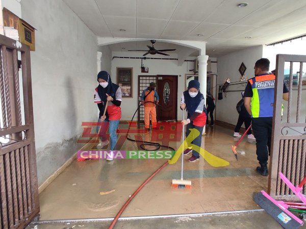 马六甲固体废料管理机构与南方环保公司人员，协助灾民清理住家。