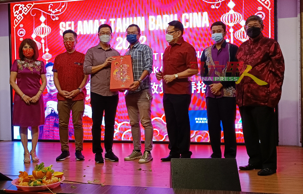 刘华才（左3）在郑德明（右起）、亚迪兹、颜炳南、胡栋强（左2）及黄明芳（左）陪同下，赠送纪念品给《中国报》高级摄影记者陈春汉。