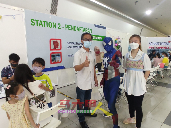 为儿童疫苗接种中心特别准备的“蜘蛛侠”，看到刘志俍（左）到场巡视，主动要求合照。右为尤丽佳。