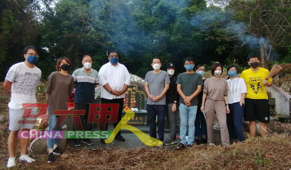 梁伟翔（左5）和家人扫墓时，遇到鲁容州议员希尔米（左4）来派发口罩。