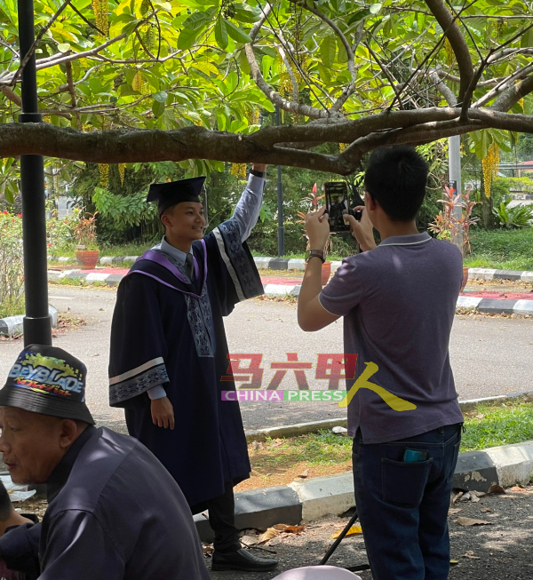 原本打算到千花园拍摄毕业照的大学生，因该花园暂时关闭，只好在入口处拍照。