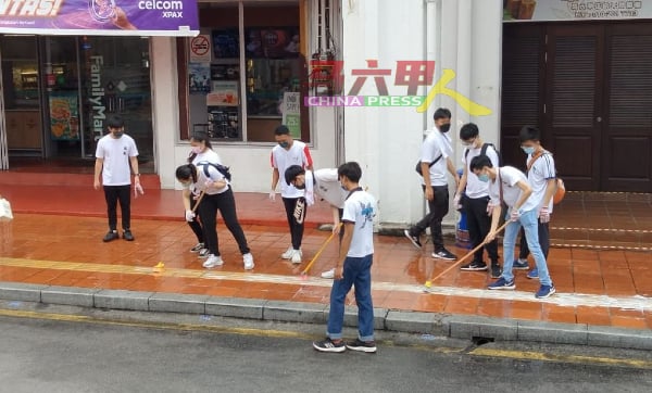 培风中学学生合力清洗鸡场街人行走道。