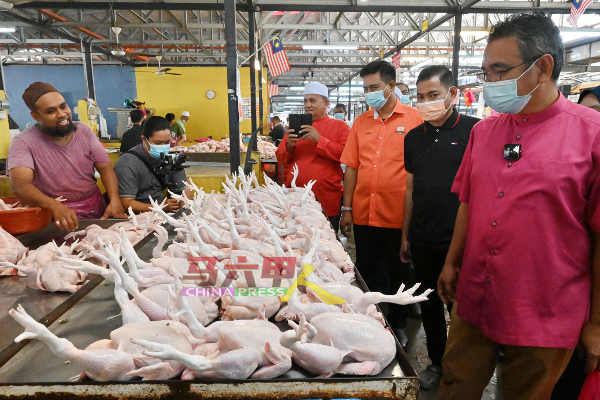 阿德里（右）到峇章大巴刹鸡肉摊，询问肉鸡供应及销量。