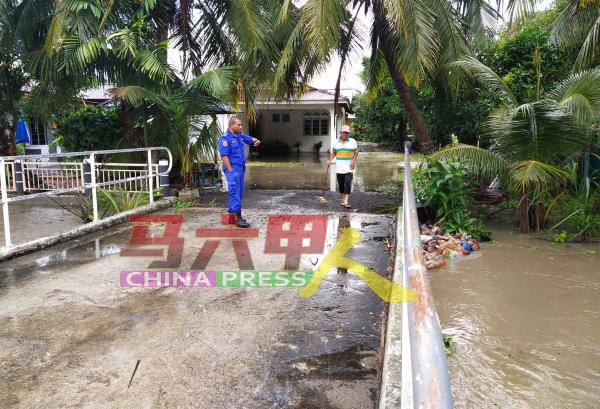 民防局队员到旺梨甘榜区，巡视河水高涨的情况。