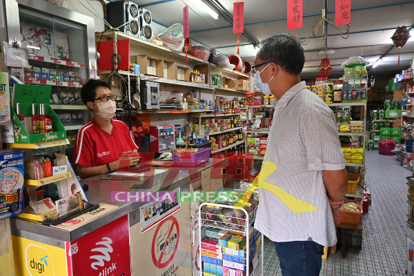 刘志俍（右）从商家口中得知，约90%消费者都戴口罩进入店里。