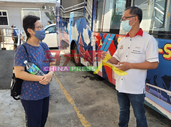 刘志俍（右）与熊新妮，就观光巴士服务交流。