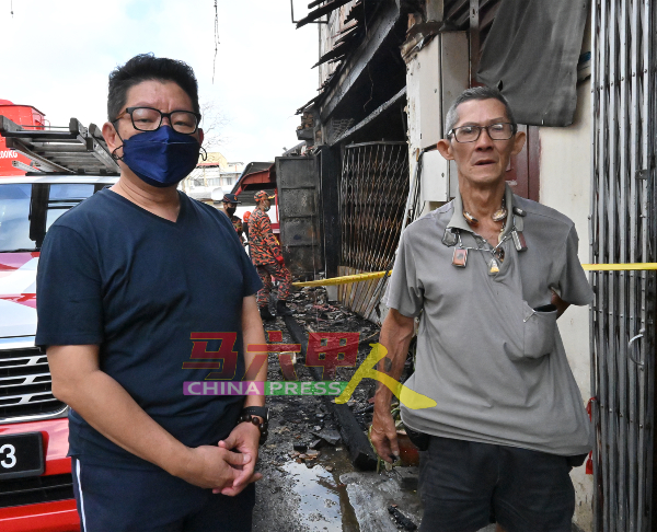 李佳胜（左）向朱福昌询问火灾经过。