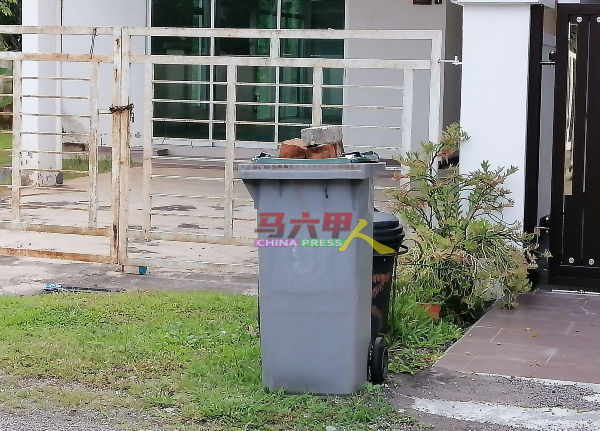 猴子经常翻找垃圾桶，垃圾散落满地，相信为避免猴子在垃圾桶觅食，居民用砖块压着垃圾桶盖。
