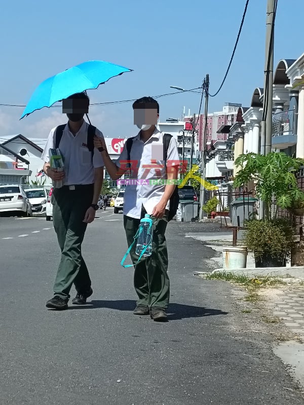 ■天气太“热情”，男中学生也受不了需要撑伞防晒。