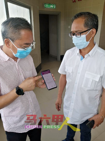 邱培栋（左）解说如何通过选举会的手机应用程式，检查选民个人登记资料。右是刘志俍。
