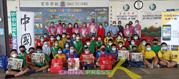 同学们举起《中国报》，开心地与嘉宾们来张大合照。