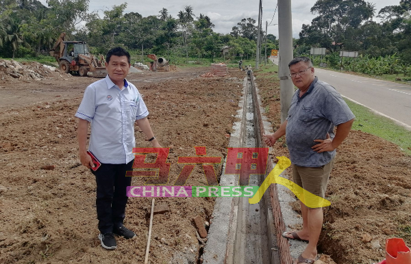 林千宏（左起）及汤开烈巡视提升沟渠工程的进度。