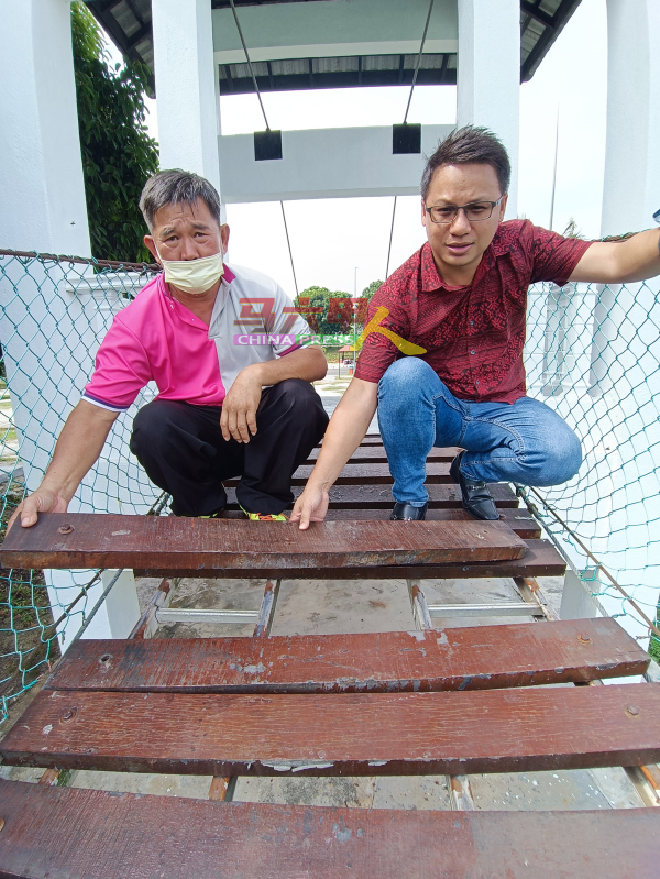 陈乾源（左起）与郑成幸展示吊桥步道的木板严重损坏。