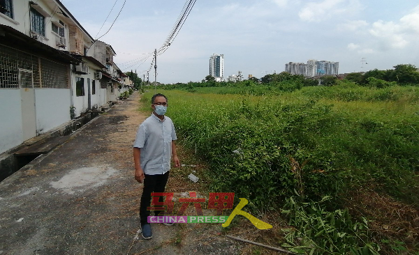 刘志俍接到居民投诉后，前往住宅后巷了解空地杂草丛生的情况。