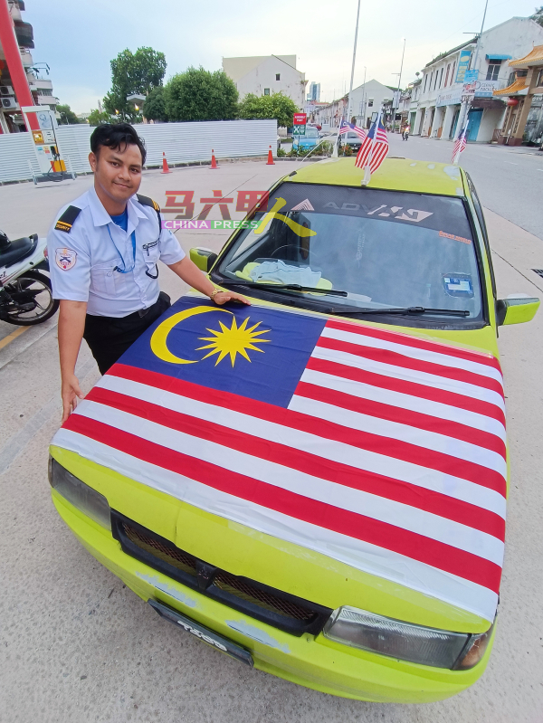 马来同胞将国旗张挂在汽车引擎盖上，展现爱国精神。