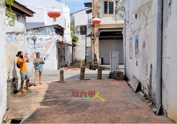 具马六甲特色的后巷壁画，吸引游客拍照留念。