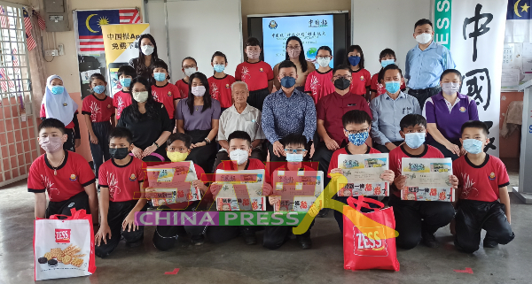 受惠同学手举《中国报》，和嘉宾们合照。