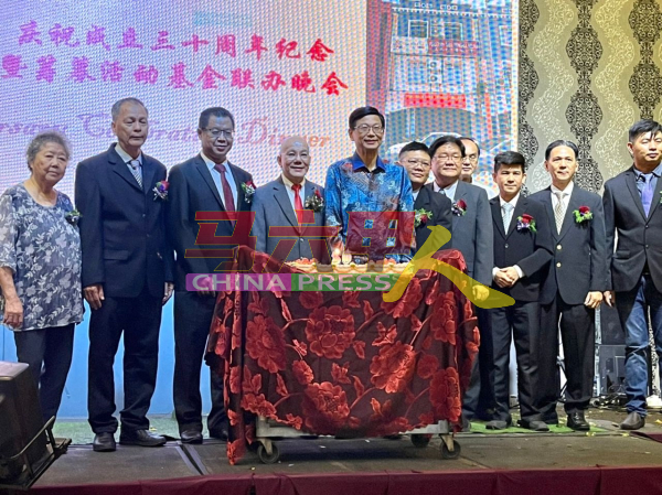 理事们在甲中华总商会会长拿督萧德坤（左5）陪同下，切蛋糕庆祝创会30周年纪念。