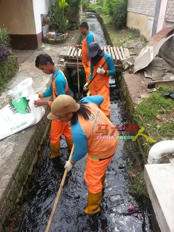 ■南方环保公司清洁工清理排水沟的泥泞。