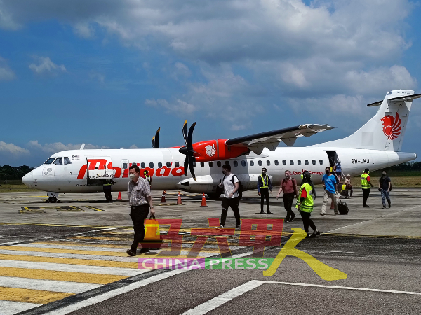 来自槟城的乘客乘飞机抵达后，步入马六甲峇株安南国际机场。