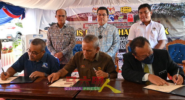 鲁斯迪（坐者右起）、依斯迈阿都拉曼、承包商代表签署移交证书，获得拉末纳里曼（站者右起）、苏莱曼及再迪佐哈里见证。