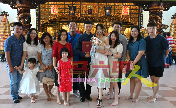 陈秋菁（右5起）与李国正在天后宫与家人分享喜悦。