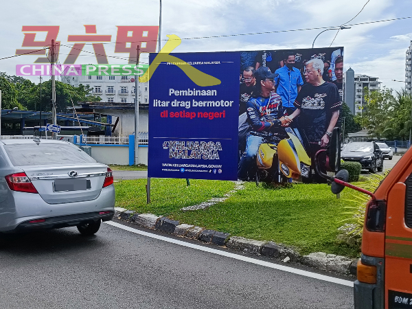 巨型的“大马一家”宣传看板竖立在怡力交通岛上，影响公路使用者视线。