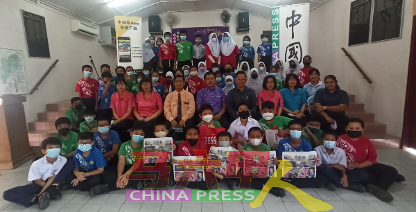 同学们举起手中的《中国报》，感谢曾华明连续14年的赞助。