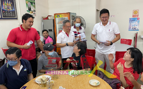 郭子毅（站者前排左起）、邱培栋和谢守钦分派甲市区国会议员选区服务报告书给民众，获得民众热情接待。