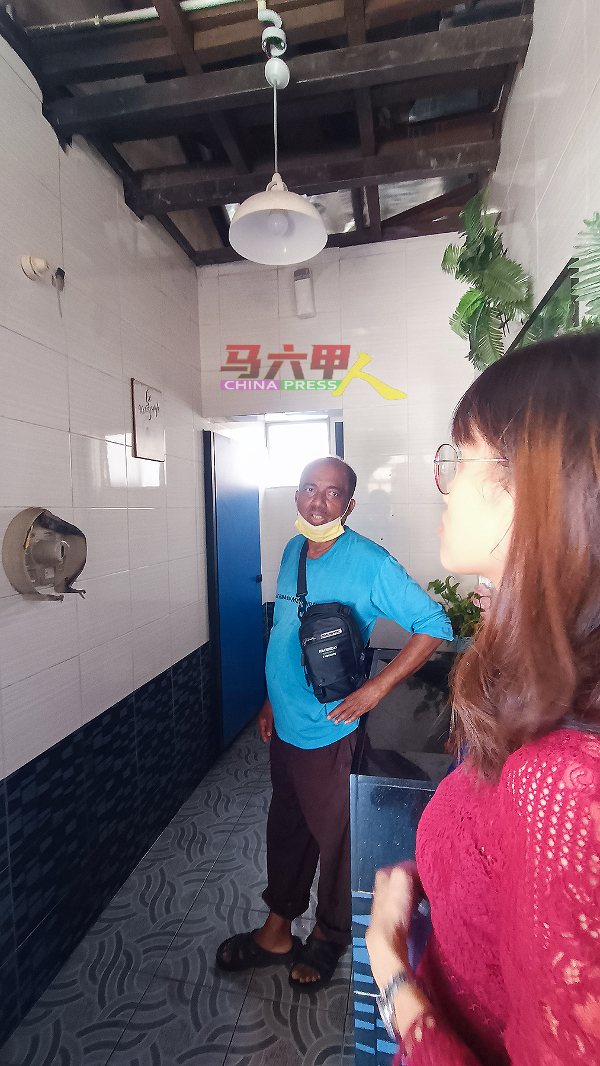 骆慧茹（右）到场向沙查汉了解公厕失火情况。