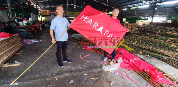 邱培栋（右）及刘志俍手上的旗帜及竹竿成本超过5令吉。