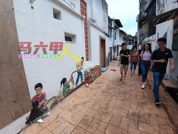 一些游客慕名前来拍照打卡，未料老街壁画已非之前般。