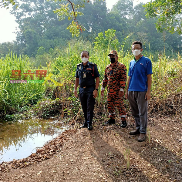 罗舜生（右）与消拯局人员查看可能引发水灾、长满野草的沼泽地。