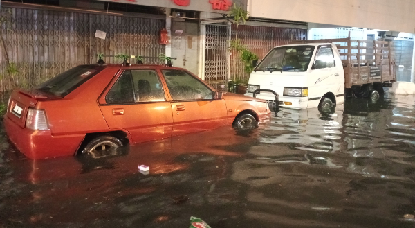 去年3月6日柏卡第2路发生严重水灾，水位高达汽车的车轮。（档案照）