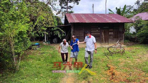 陈天丁（左）与其中一名残疾孩子，住在简陋的木屋，右为谢守钦。