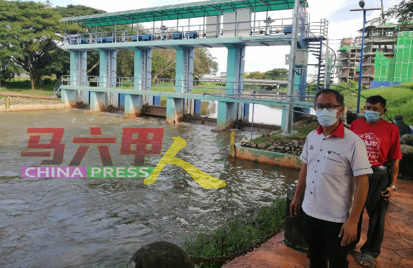 民众担心水位太高，刘志俍（左起）接获反映后，与烈斯力前往峇株汉拔水闸了解情况。