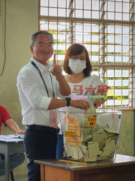 邱培栋（左）在妻子李慧贞陪同下，在武吉波浪华小投票中心投票。