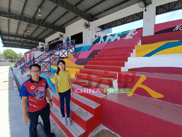 陈炜建（左起）与骆慧茹了解经修复彩绘工作的的足球场看台。