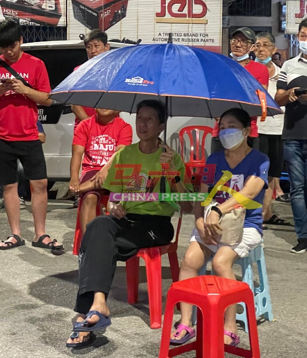 民众撑伞在雨中聆听政治讲座，丝毫不受雨天影响。