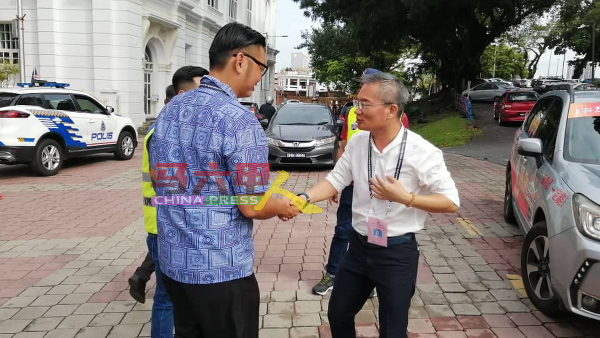 高启尧（左起）与邱培栋，不约而同到中央警局了解警员提早投票进展。