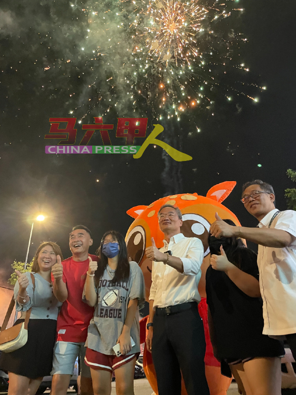邱培栋（右3）宣布胜选后，获得支持者要求合照及燃放烟花庆祝，右为刘志俍。