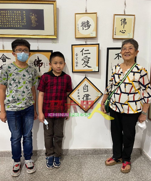 82岁陈金梅（右起）与孙子苏祖泽及苏祖乐的作品，展示在马六甲孔教会师生书法展。
