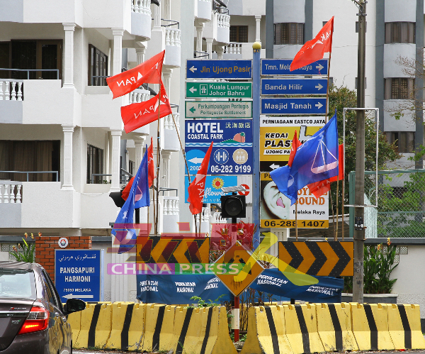 各政党漠视公共安全，一堆旗帜插在交通岛上遮挡路牌的视野。