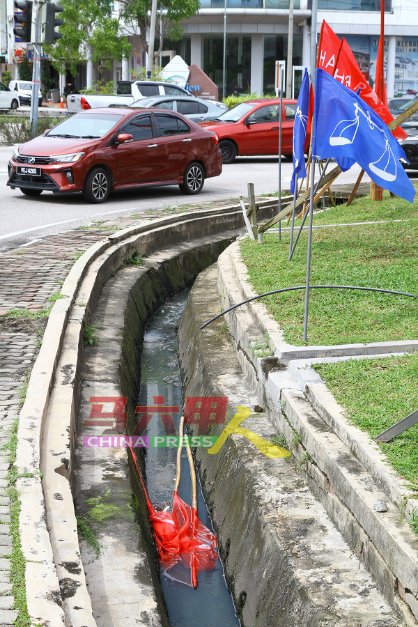 位于哥打拉沙马那的希盟旗帜，掉入水沟阻碍排水。